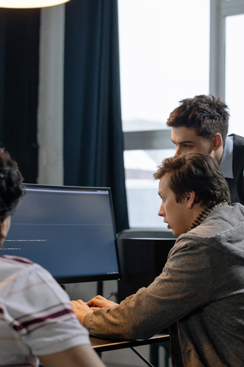 Group of developers working together on a computer programming project indoors.